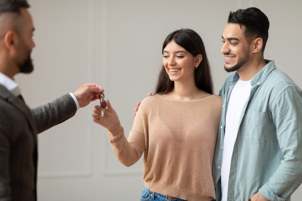 Real Estate Agent Giving Keys To Excited Buyers